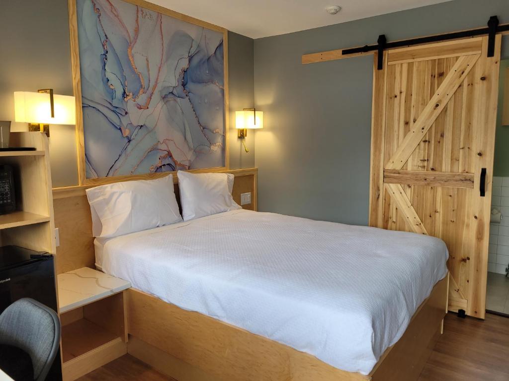 a bedroom with a large bed and a sliding door at Greenview Inn Riverhead in Riverhead
