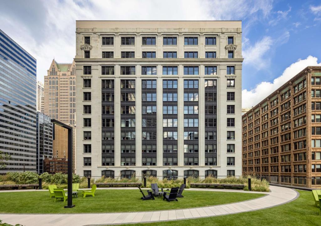 Hilton Garden Inn- Chicago Central Loop في شيكاغو: مبنى أبيض كبير مع حديقة أمامه