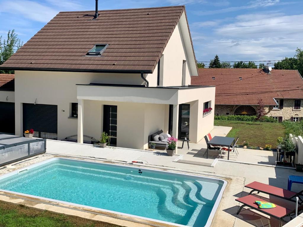 a swimming pool in front of a house at Superbe villa avec piscine proche de belfort in Meroux