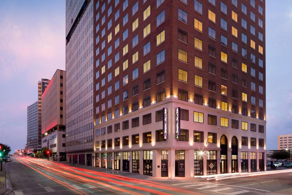 un grand bâtiment dans une rue de la ville avec des bâtiments dans l'établissement Hampton Inn & Suites Dallas Downtown, à Dallas
