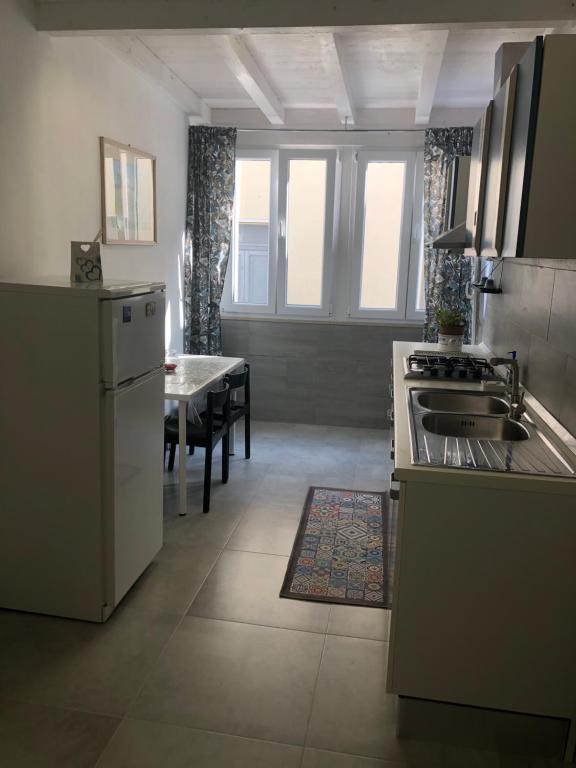 una cucina con frigorifero, lavandino e tavolo di Nido di Puglia 2 a Mola di Bari