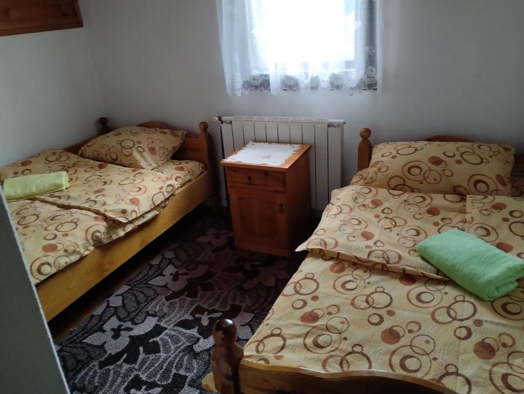 een slaapkamer met 2 bedden, een tafel en een raam bij VILA ANTONIJE in Šljivovica