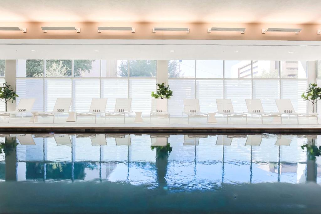 una fila de sillas blancas sentadas junto a una piscina en Hampton Inn & Suites Dallas Downtown en Dallas
