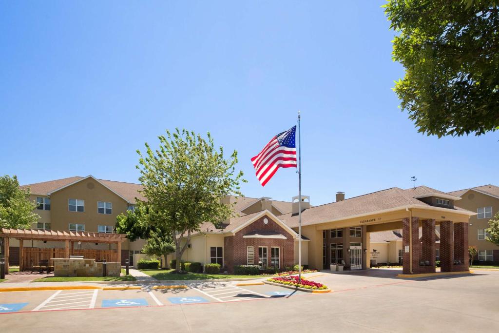 an american flag flying in front of a building at Homewood Suites by Hilton Dallas-Park Central Area in Dallas