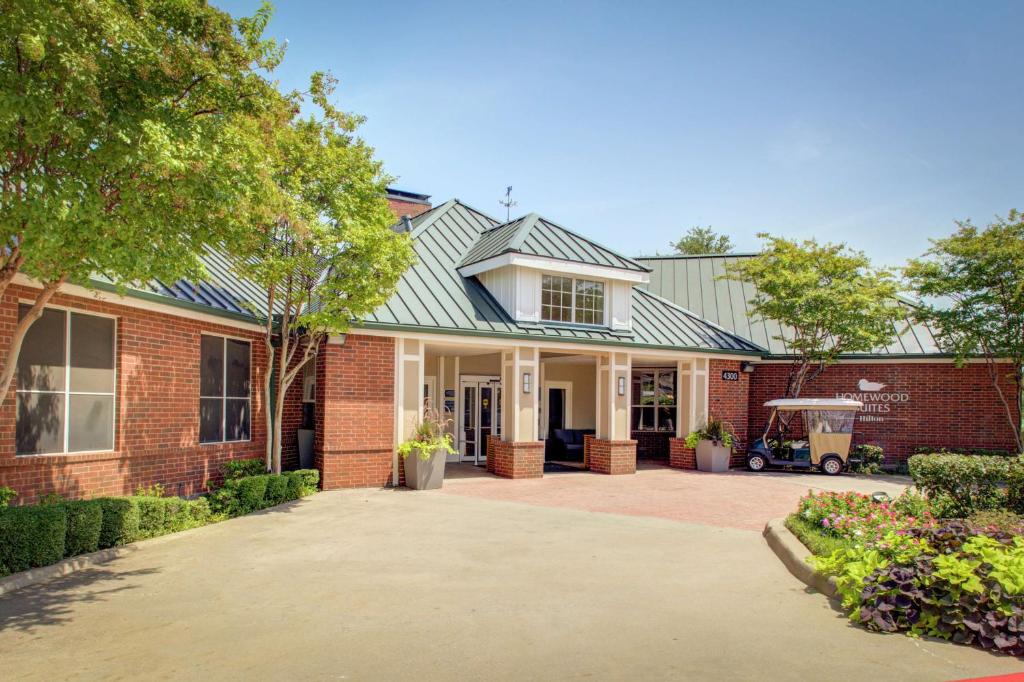 a red brick house with a green roof at Homewood Suites by Hilton Dallas-Irving-Las Colinas in Irving