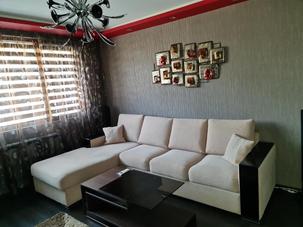 GH Apartment Vratza في Vratsa: غرفة معيشة مع أريكة بيضاء وطاولة