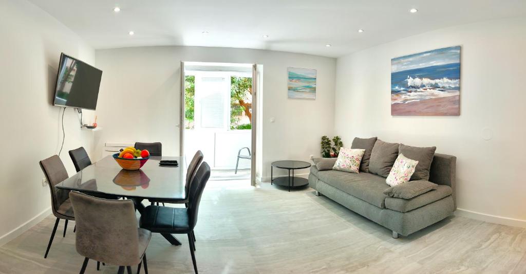 ein Wohnzimmer mit Sofa und Tisch in der Unterkunft Rose - Heart of Zadar in Zadar