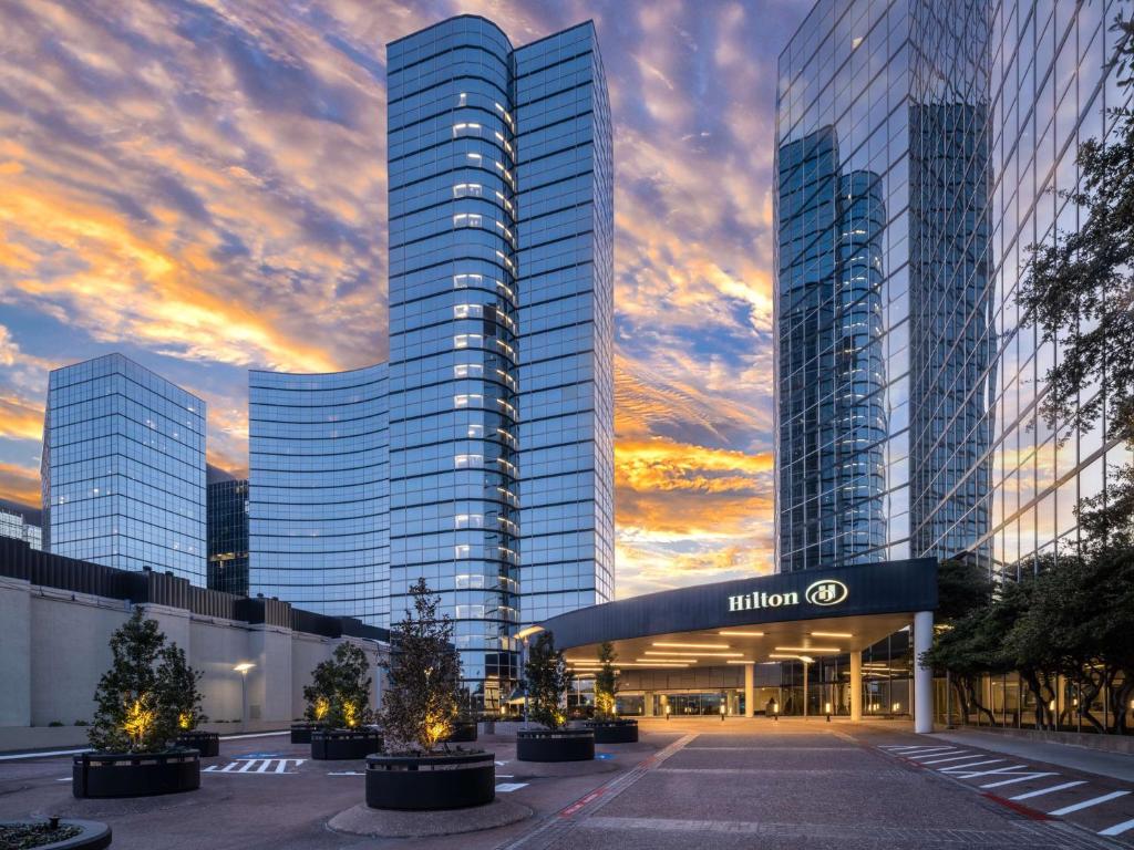 un edificio con una puesta de sol delante de él en Hilton Dallas Lincoln Centre en Dallas
