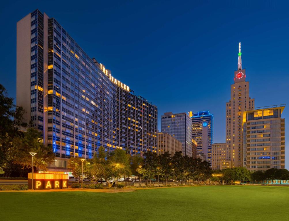a city at night with a park in the foreground at The Statler Dallas, Curio Collection By Hilton in Dallas