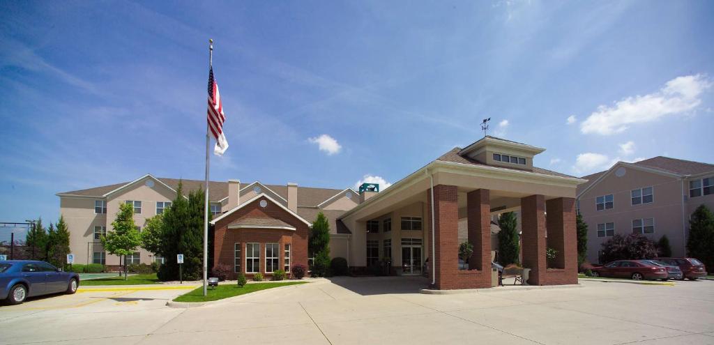 un edificio con una bandera americana delante de él en Homewood Suites Grand Rapids en Grand Rapids