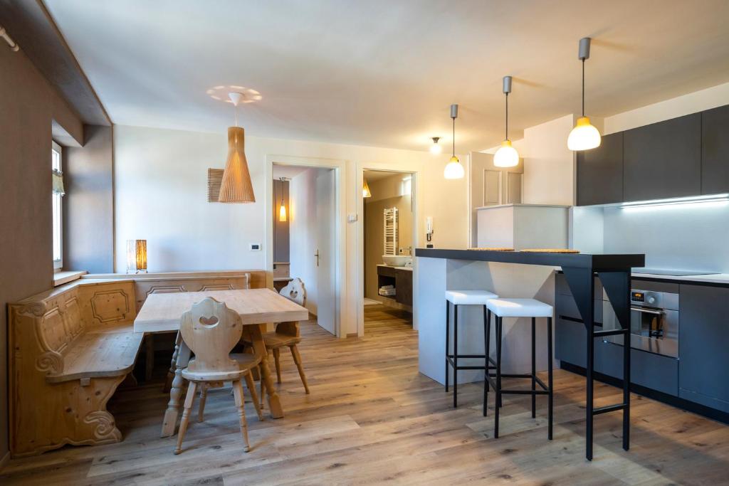 a kitchen with a table and some chairs in a room at Ciasa Buro - Ron in Moena