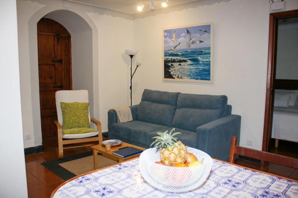 un soggiorno con divano blu e tavolo di Casa do Largo - Açores a Ponta Delgada