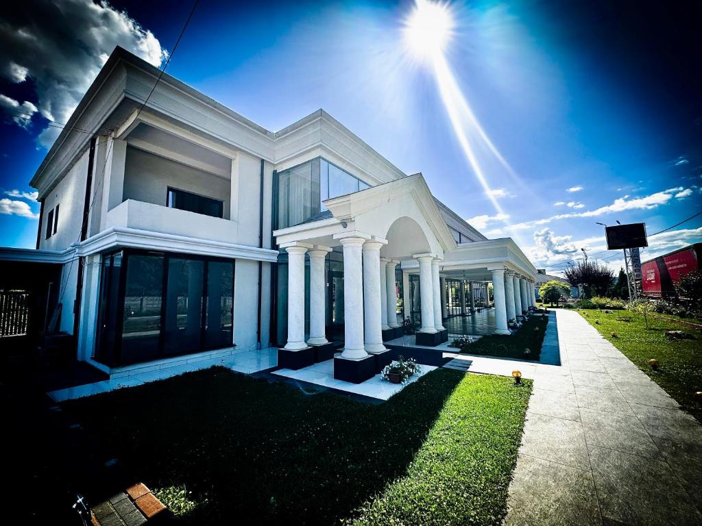 uma casa branca com o sol no céu em Pensiunea Cristal em Racoviţa