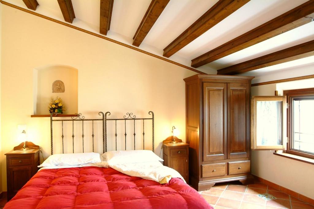 um quarto com uma cama com um cobertor vermelho em Il Castello em Petralia Sottana