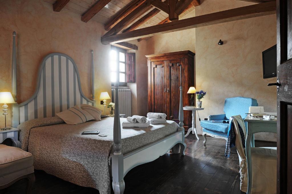 a bedroom with a bed and a table and a chair at Antica Locanda Lunetta in Màndas