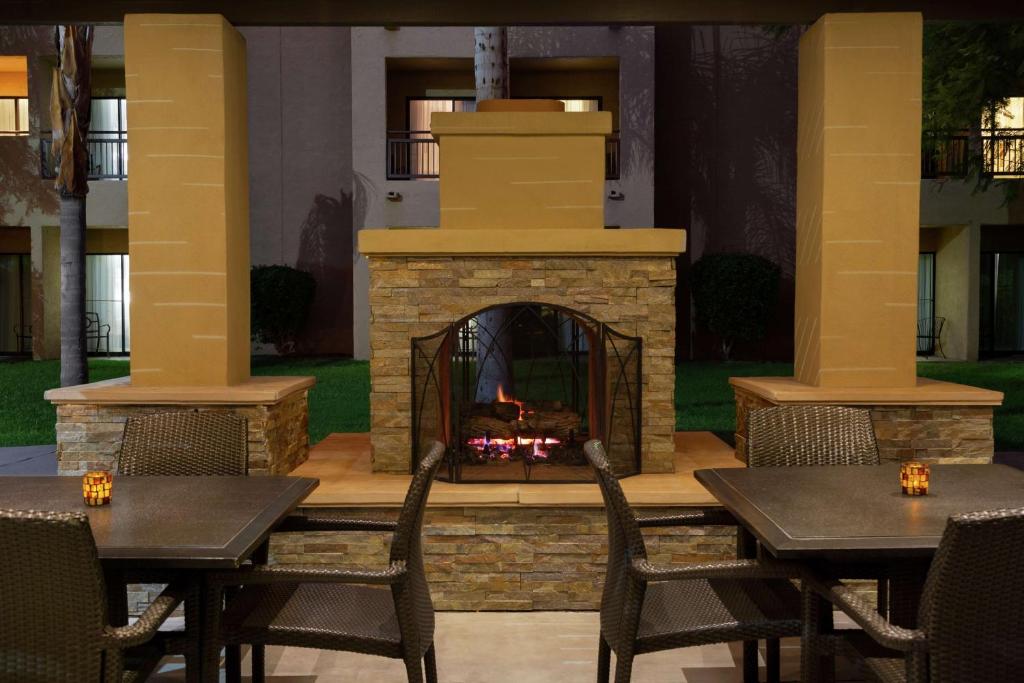 テンピにあるEmbassy Suites by Hilton Phoenix Tempeの暖炉(テーブルと椅子付)が備わるパティオ