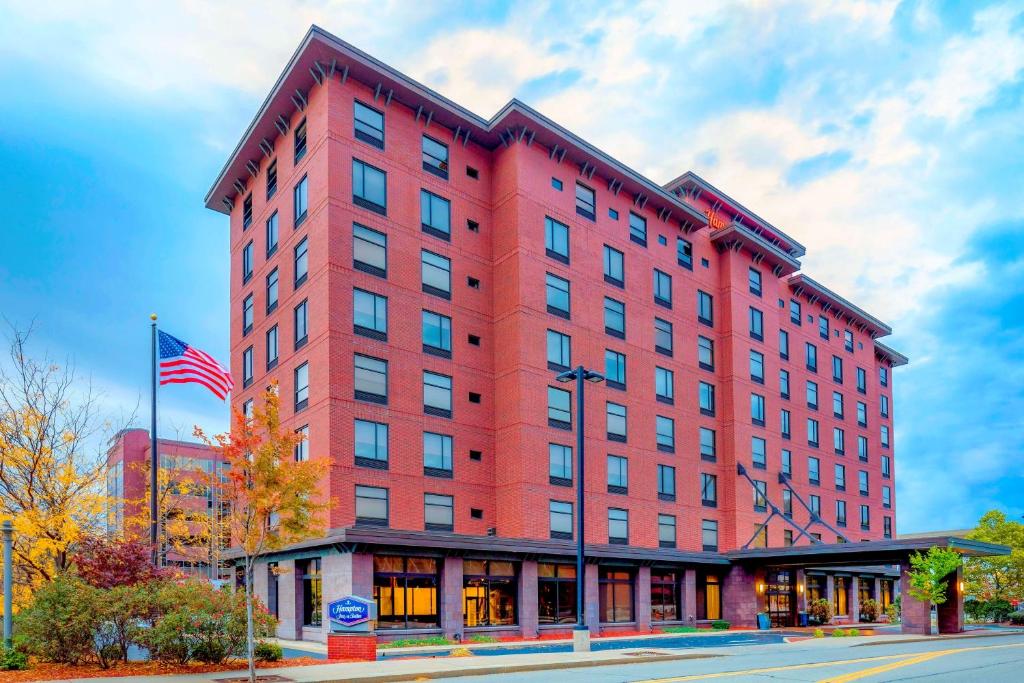 Um edifício vermelho com uma bandeira americana à frente. em Hampton Inn & Suites Pittsburgh Downtown em Pittsburgh