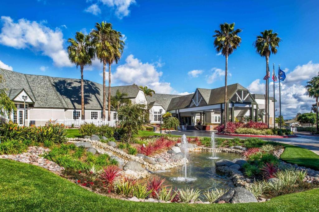 a home with a fountain and palm trees at Hilton San Diego/Del Mar in San Diego