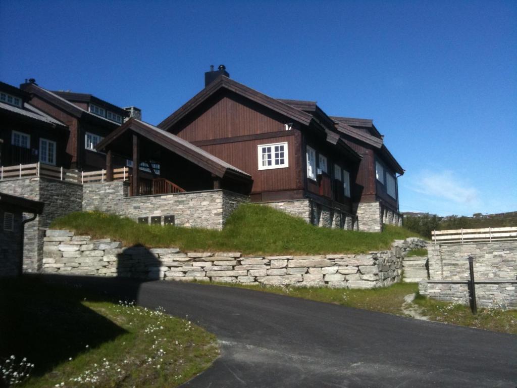 una casa su una collina con un muro di pietra di Havsdalsgrenda Geilo Apartments a Geilo