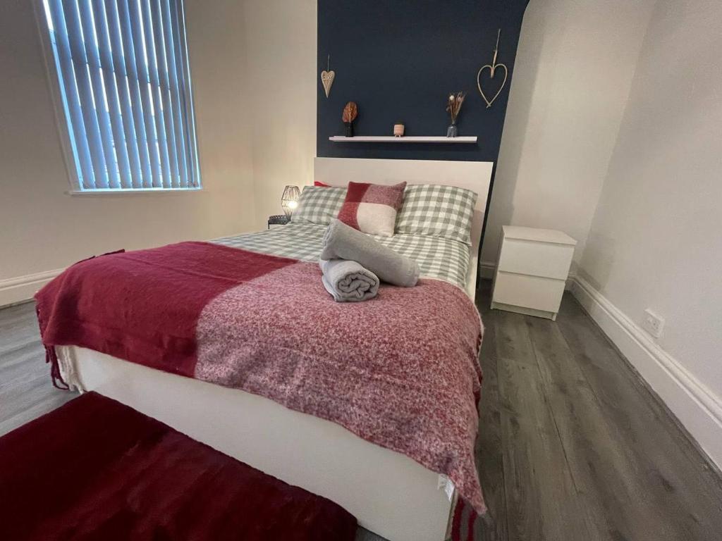 a bedroom with a large bed with a red blanket at Joyous Private Room in City Centre in Liverpool