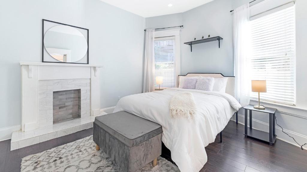 a white bedroom with a bed and a fireplace at Classic 1 Bedroom Apt in Midtown, ATL in Atlanta