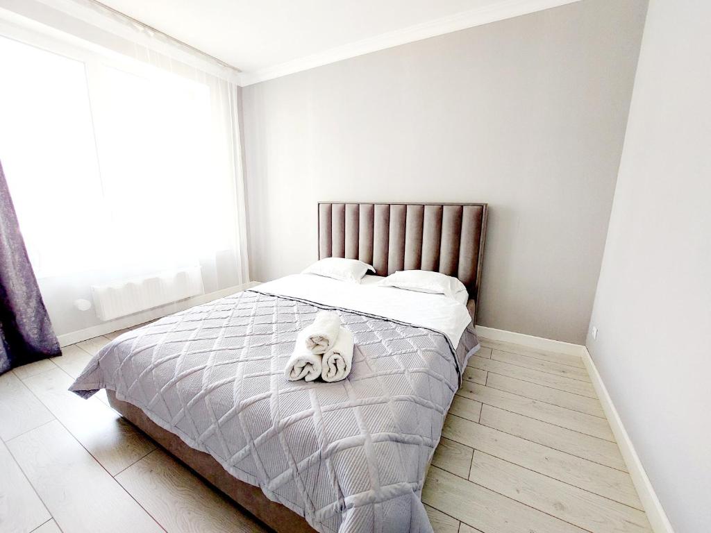 Апартаменты в ЖК Only Sun في Prigorodnyy: غرفة نوم عليها سرير محشوة