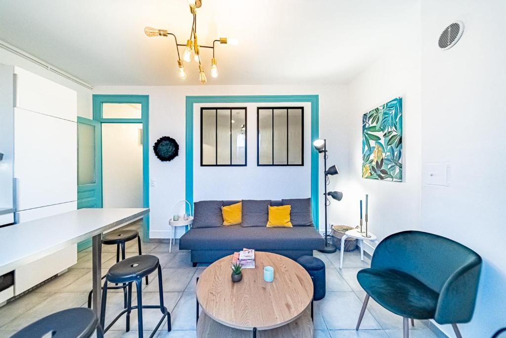 een woonkamer met een bank en een tafel en stoelen bij Le Jean Jaures- 2 chambres- Gerland-Tony Garnier in Lyon