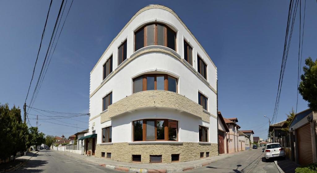 um grande edifício branco com um topo redondo em Villa Casafina Serviced Apartments em Mangalia