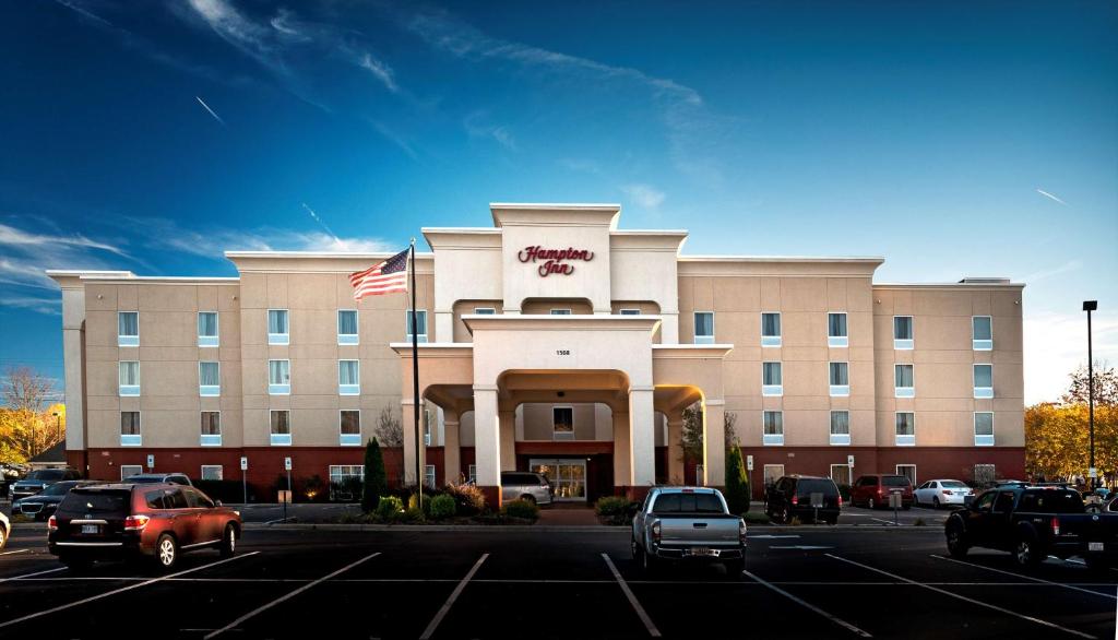 um grande edifício com carros estacionados num parque de estacionamento em Hampton Inn Statesville em Statesville