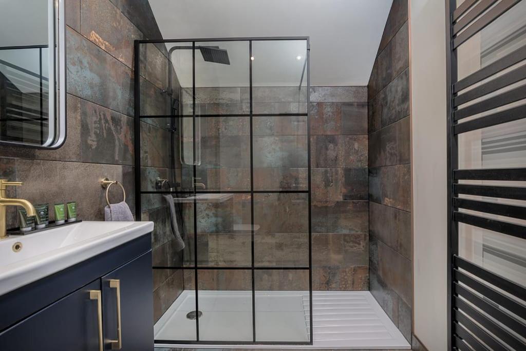 a bathroom with a glass shower and a sink at Paradise Square-Remodelled 18th Century Apartment in Sheffield