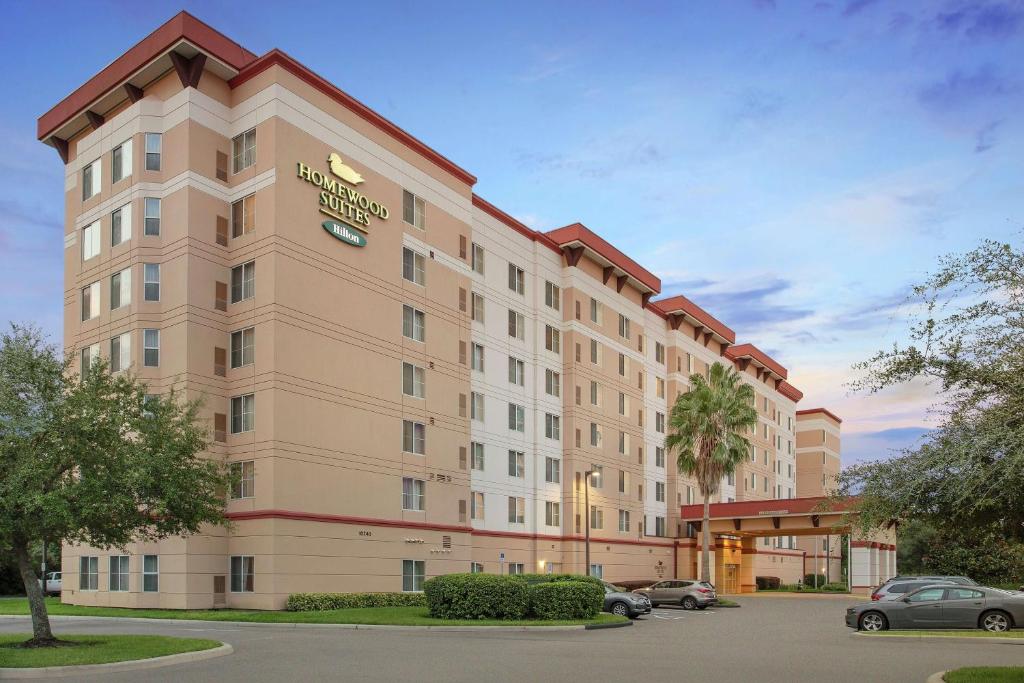 ein Hotelgebäude mit einem Auto auf einem Parkplatz in der Unterkunft Homewood Suites by Hilton Tampa-Brandon in Tampa