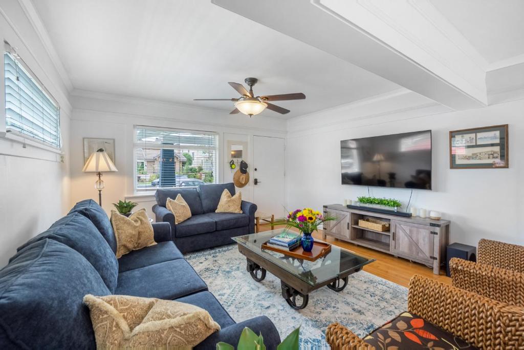 sala de estar con sofá azul y TV en Beach & Breezes, en Huntington Beach