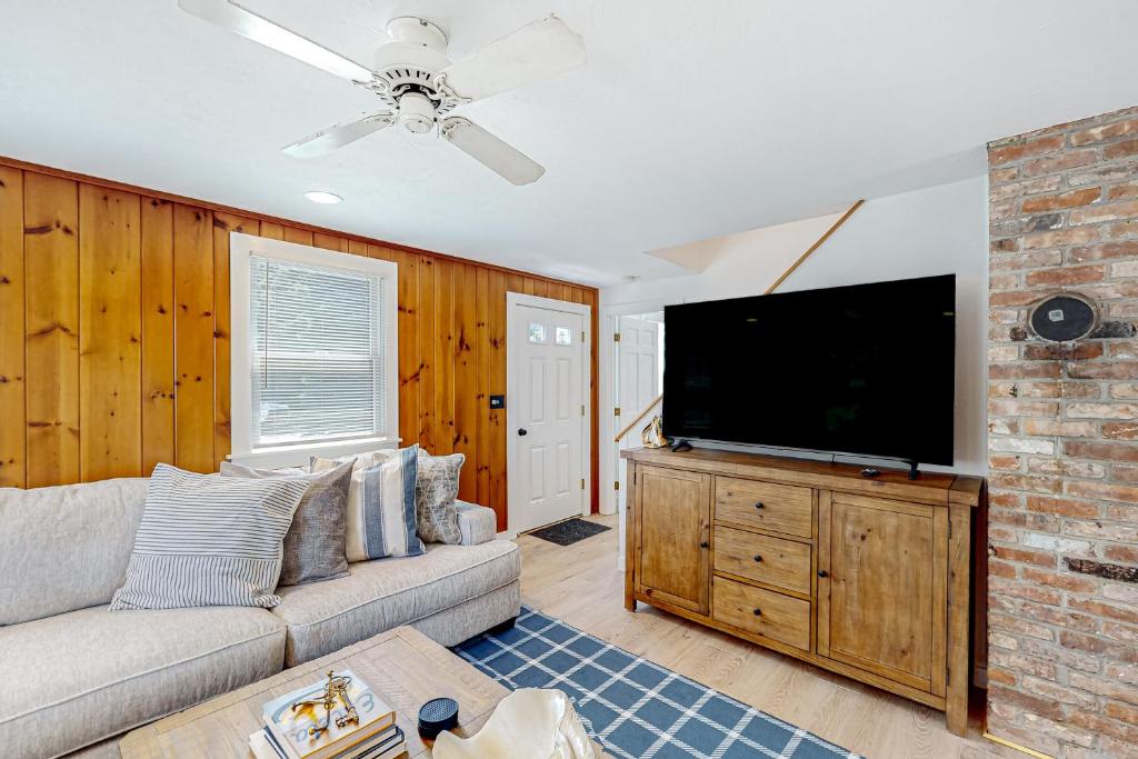 un soggiorno con divano e TV a schermo piatto di Sail Away Cottage a Nantucket