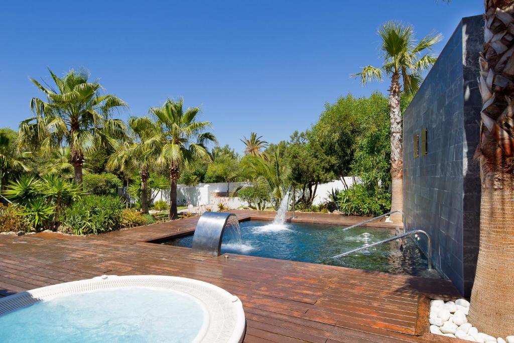 a swimming pool with a water fountain in a yard at Hotel Boutique Ses Pitreras in San Antonio Bay