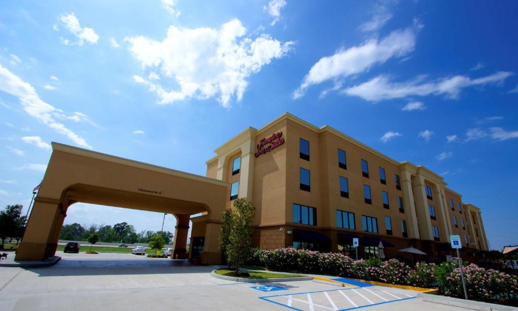 um edifício de hotel com um arco em frente em Hampton Inn & Suites Tomball em Tomball