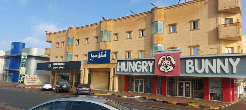 a building with signs on the side of a street at سما رفحاء للشقق المخدومة in Rafha