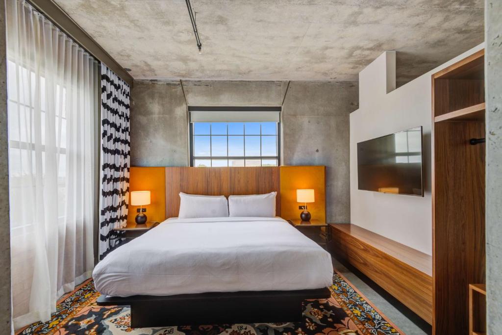 a bedroom with a large bed and a large window at NYLO Dallas Plano Hotel, Tapestry Collection by Hilton in Plano