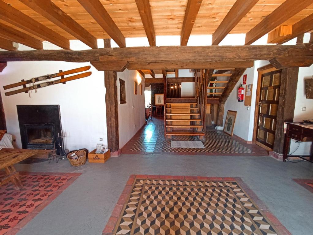 a living room with wooden ceilings and a fireplace at Hotel Rural La Encantada en Riaza in Becerril