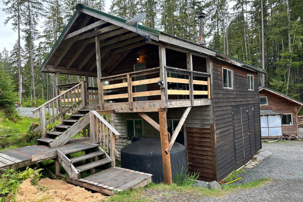 una casa en el árbol con una escalera que conduce a ella en Whale Pass Adventure Property 