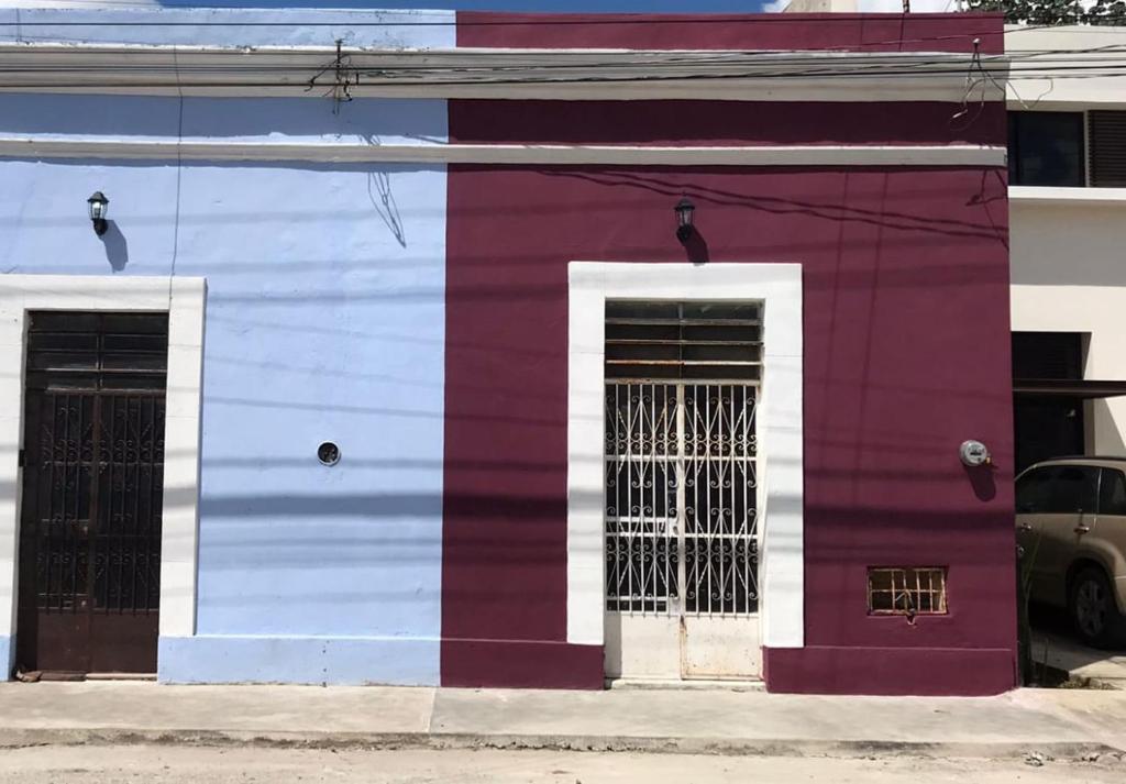 een paars en wit gebouw met twee ramen bij LOFT 82 in Mérida