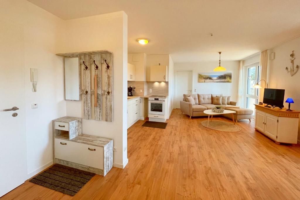 a large living room with a couch and a kitchen at Bernsteinquartier Ferienwohnung Blaues Fenster in Kölpinsee