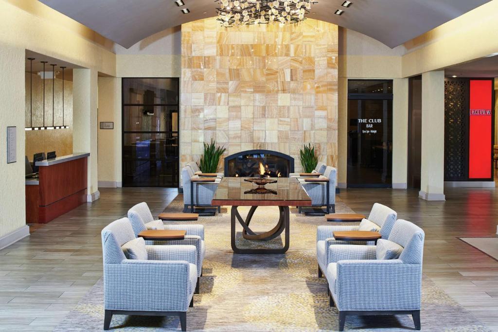 a lobby with chairs and a table and a fireplace at DoubleTree by Hilton Hotel Salt Lake City Airport in Salt Lake City