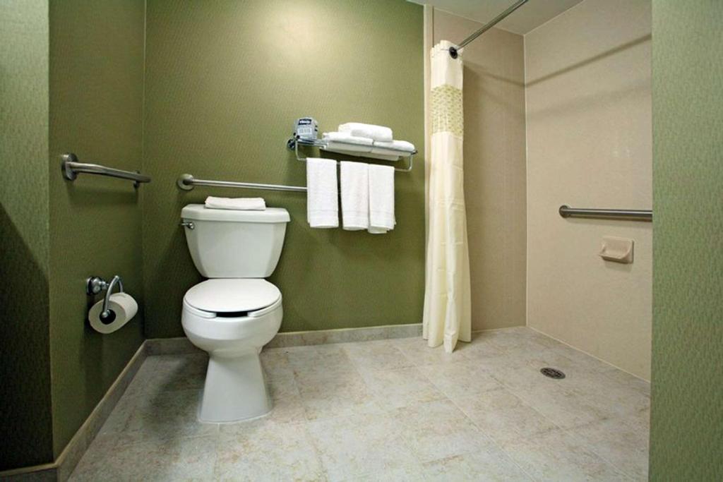 a bathroom with a toilet and a shower with towels at Hampton by Hilton Reynosa Zona Industrial in Reynosa