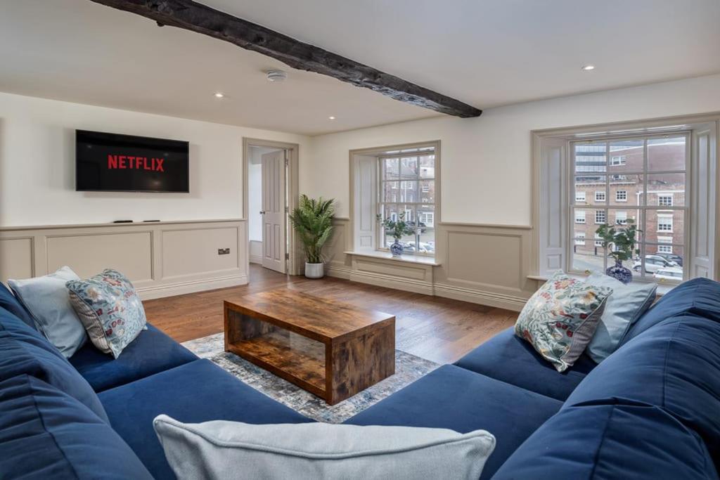 a living room with a blue couch and a table at Paradise Square - Remodelled 18th Century Apartme in Sheffield