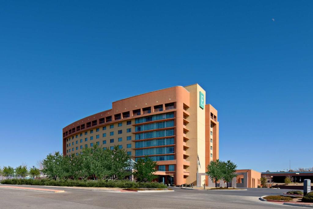 a large office building with a road in front of it at Embassy Suites by Hilton Albuquerque in Albuquerque