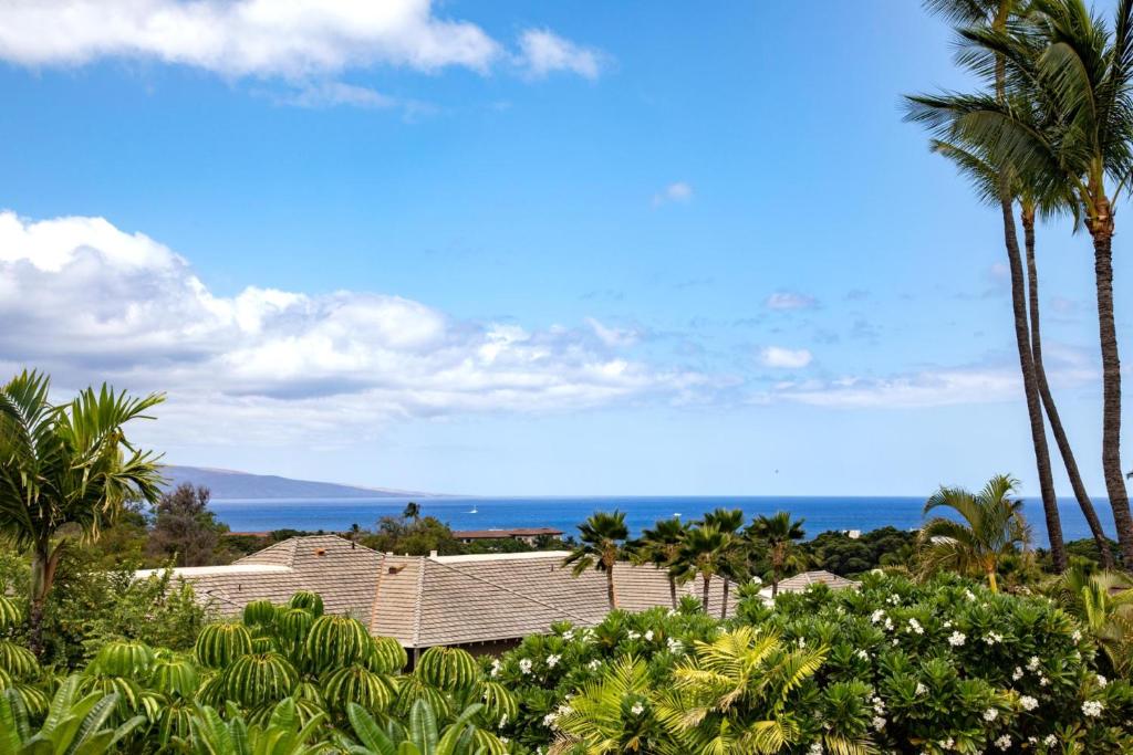 a view of a house with palm trees and the ocean at KBM Resorts Grand Champions GCH 42 NEW Remodeled 2 Bedrooms Villa in Heart of Wailea Includes Rental Car in Wailea