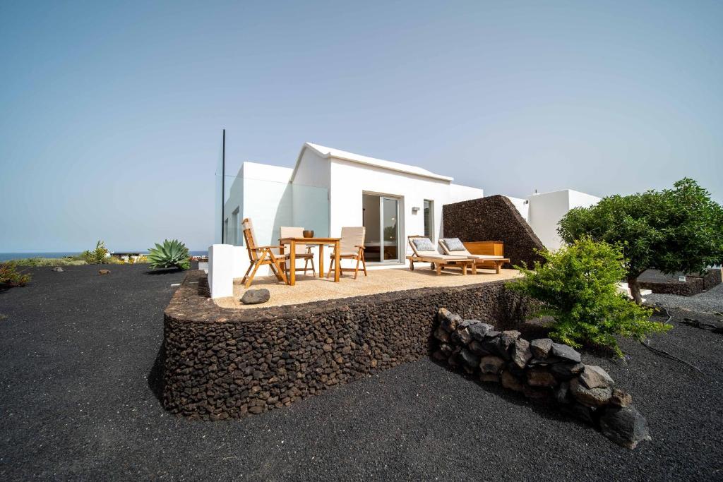 ein Haus mit einer Terrasse mit einem Tisch und Stühlen in der Unterkunft Vaya Querida in Mala