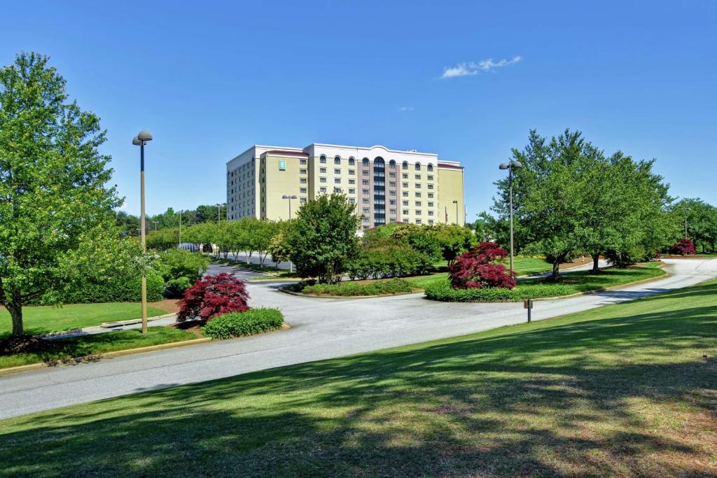 una carretera en un parque con un edificio al fondo en Embassy Suites Greenville Golf Resort & Conference Center, en Greenville