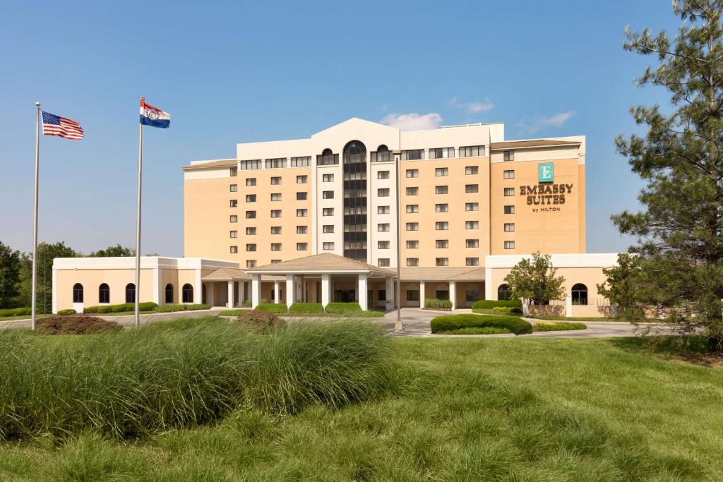 a hotel with an american flag in front of it at Embassy Suites by Hilton Kansas City International Airport in Kansas City