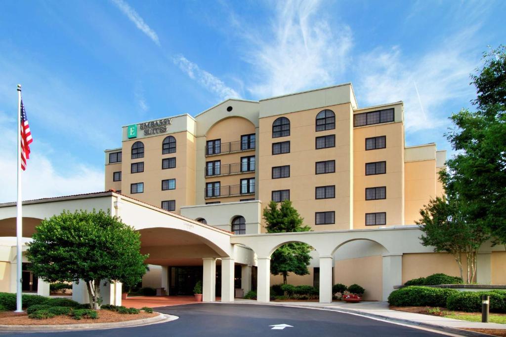 a hotel with an american flag in front of it at Embassy Suites by Hilton Greensboro Airport in Greensboro